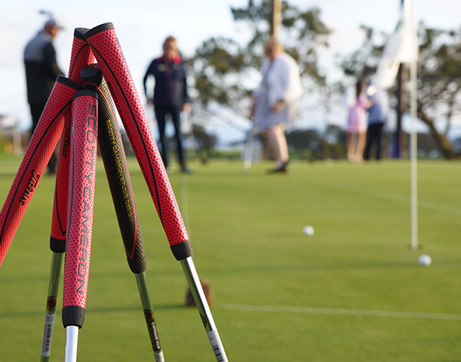 Putter handles in foreground and people in background