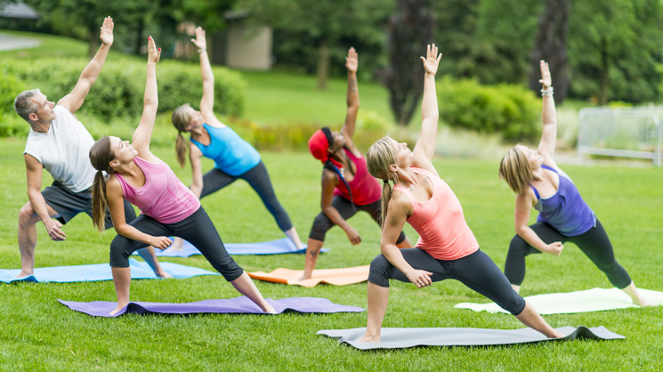 Group of people enjoying yoga outdoors