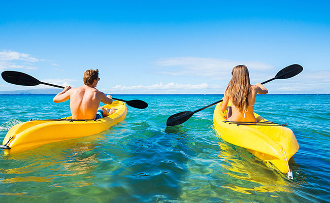Newlyweds kayaking on their honeymoon in La Jolla.