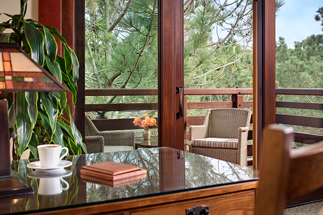Sitting at desk in Signature room overlooking lush garden