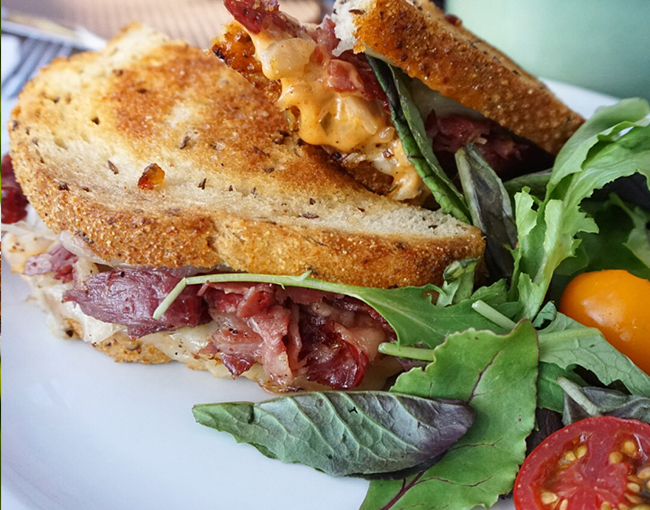 Reuben sandwich with corned beef, sauerkraut, Swiss cheese, thousand island dressing on grilled rye available during weekend brunch in La Jolla at The Grill at Torrey Pines