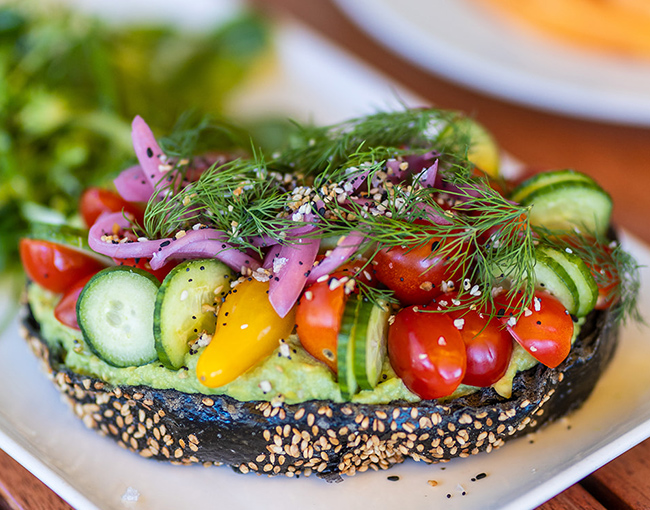 Avocado toast topped with fresh vegetable served during weekend brunch in La Jolla at The Gril