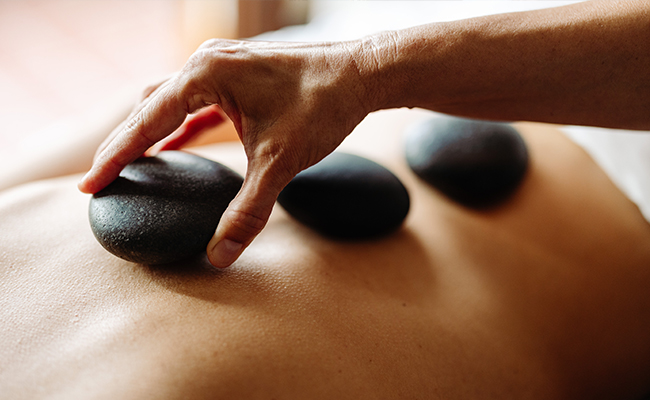 Woman getting a hot stone massage at The Spa at Torrey Pines