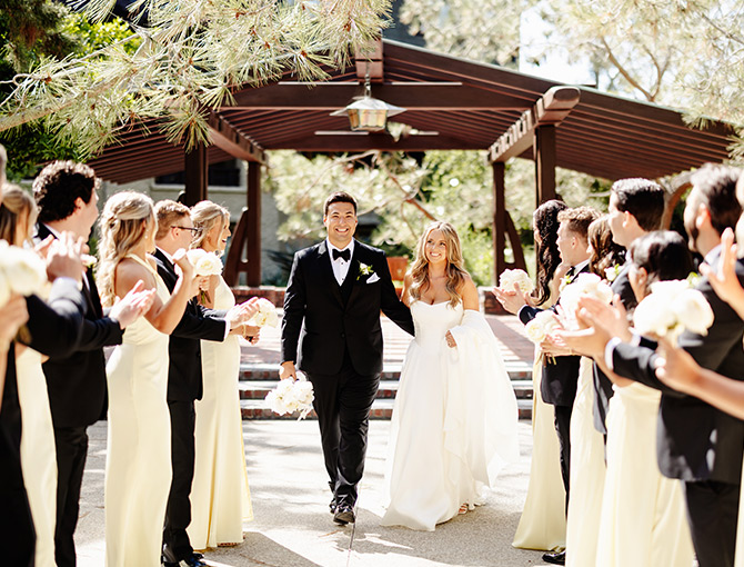 Bride and groom walking along the beach before their wedding reception at The Lodge at Torrey Pines.