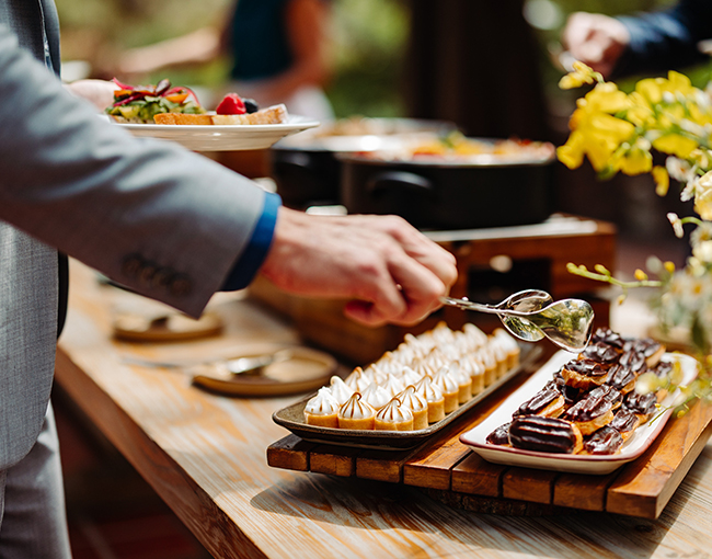 Group attendee selecting fresh catered items from the table