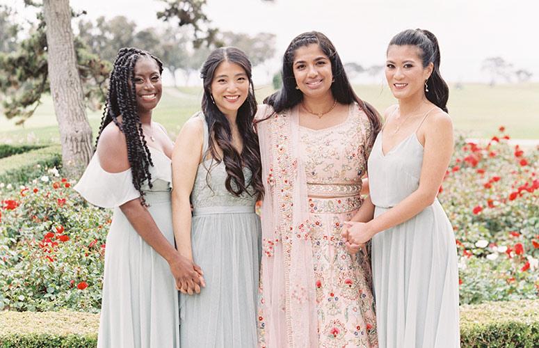The boho bride and her bridesmaids posing for a photo on the Arroyo Terrace at The Lodge at Torrey Pines in La Jolla, CA